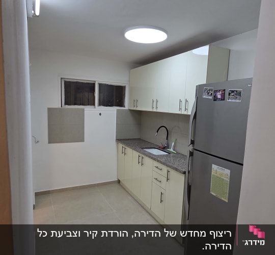 מטבח משופץ עם ארונות, כיור ומקרר
